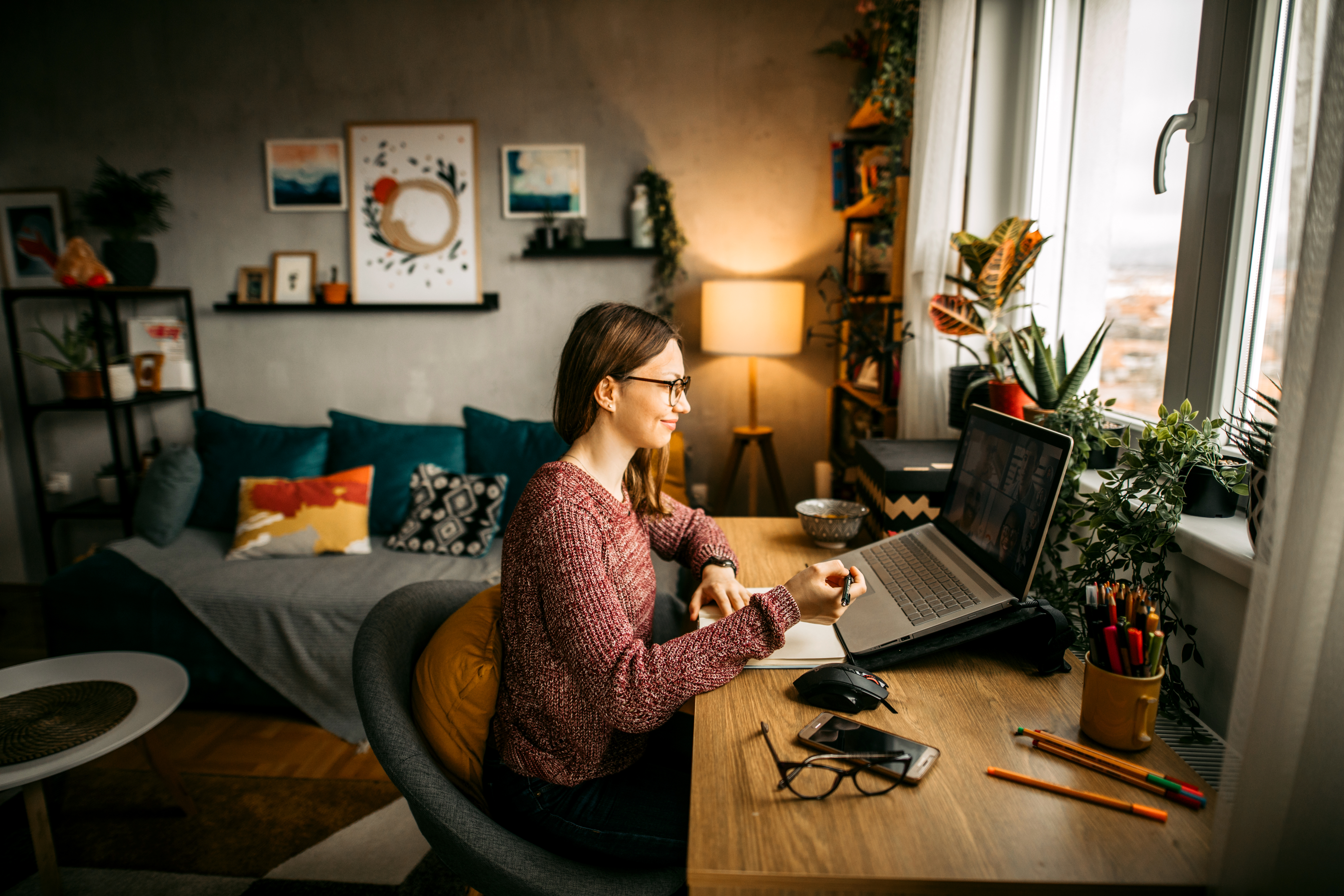 larger image of woman in glasses working on a laptop at home